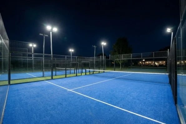 Blue padel court with LED floodlights at night